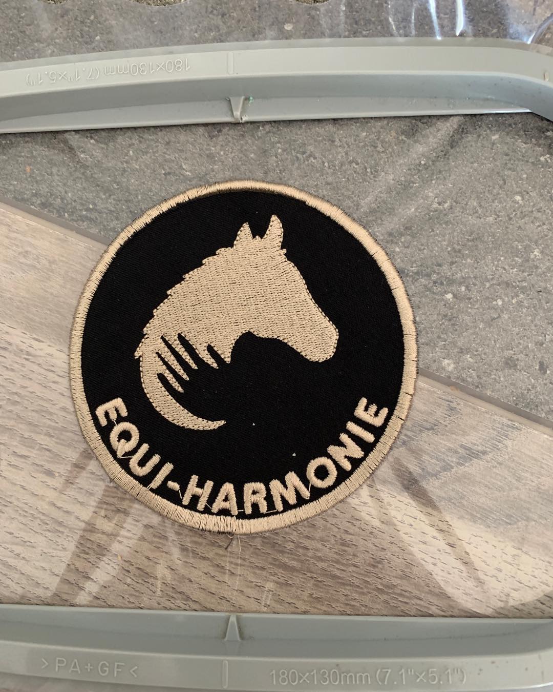 Détail de l’écusson Equi-Harmonie dans le cadre de broderie